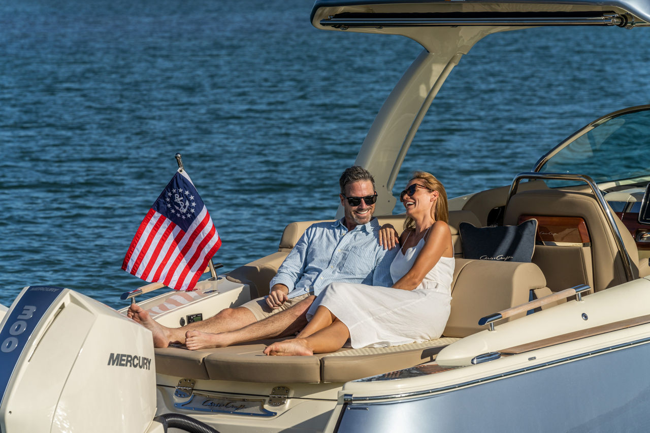 Couple sitting on the sunpad of a Launch 31 GT