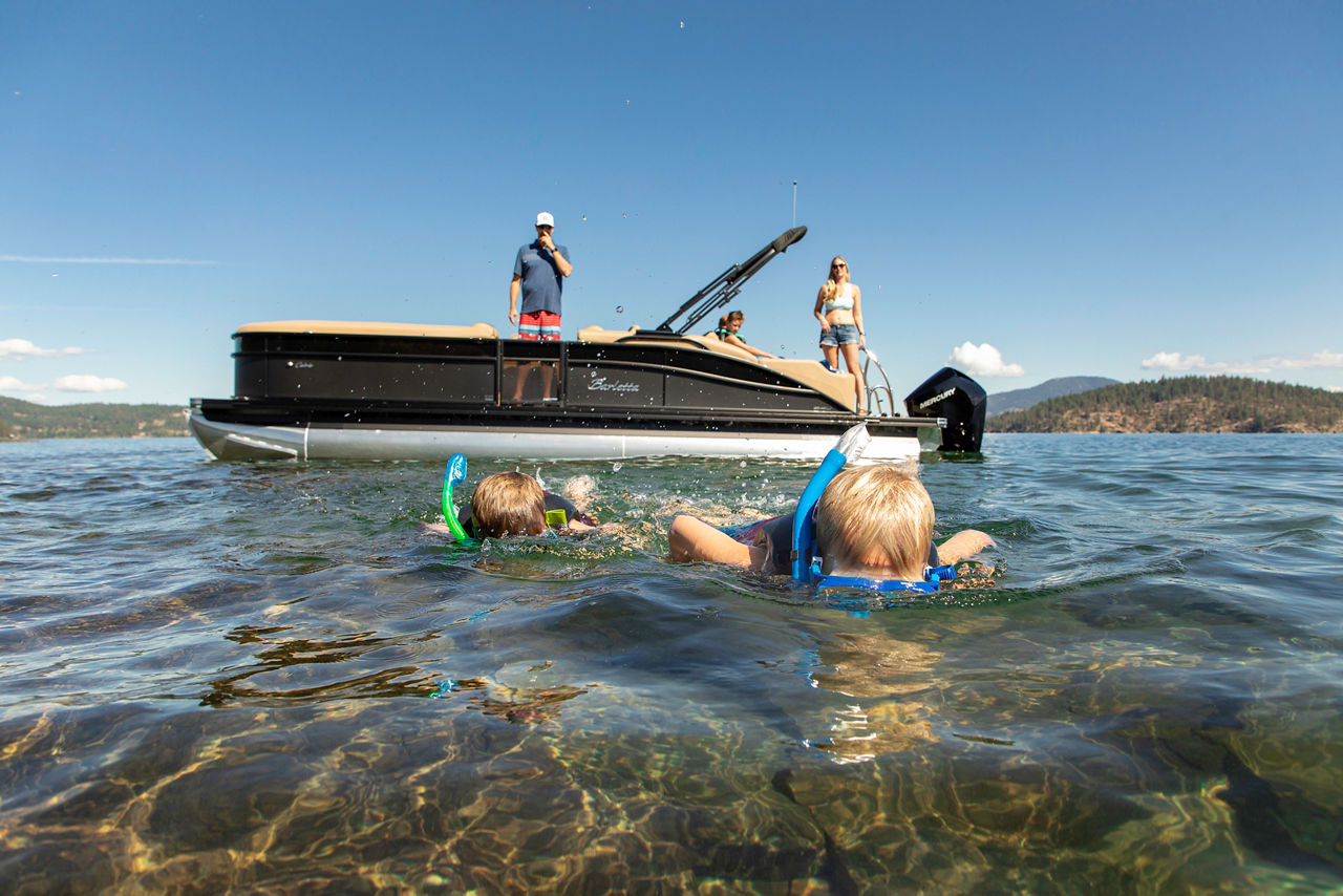 image of children swimming by boat