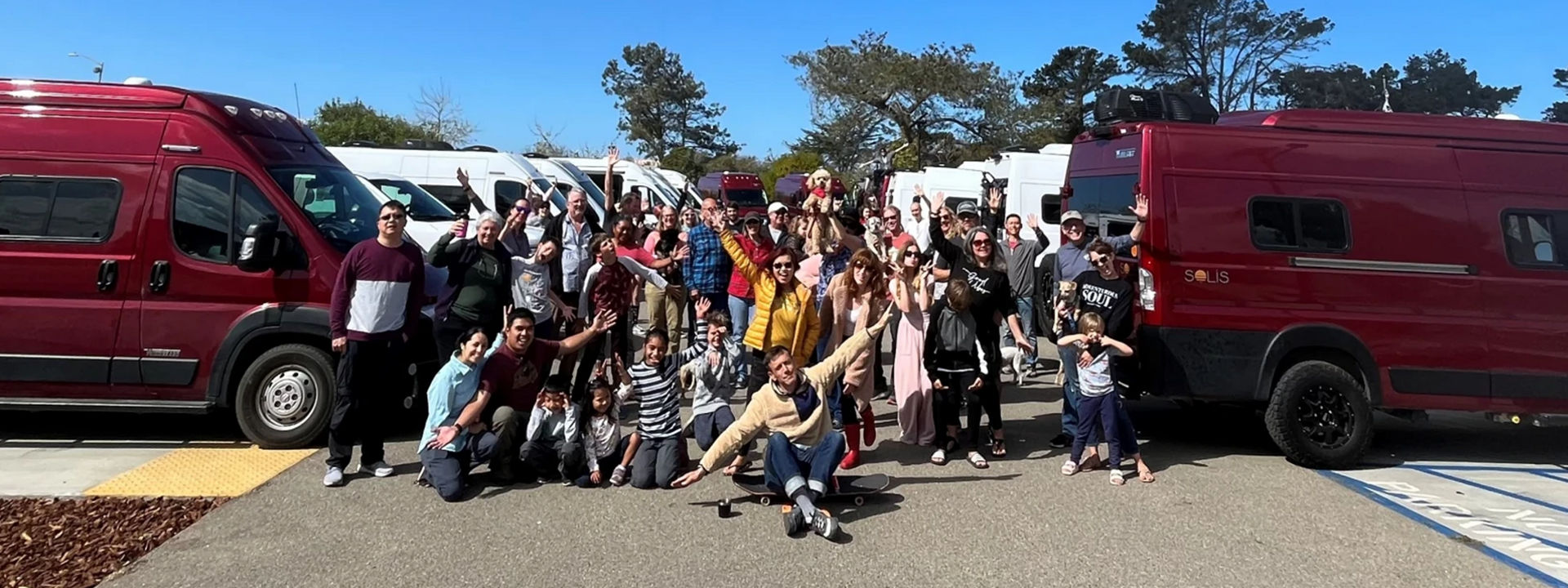 group photo of adults and children in front of RVs