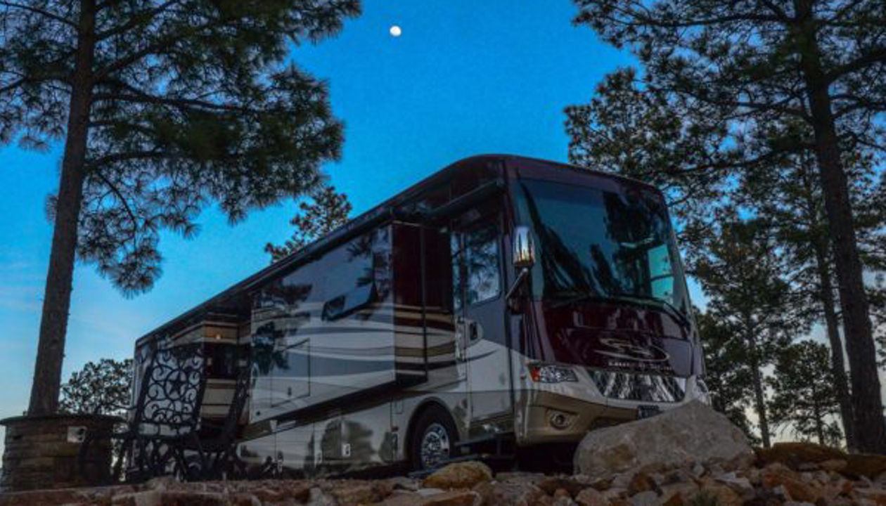 View of RV at dusk with moon in the sky