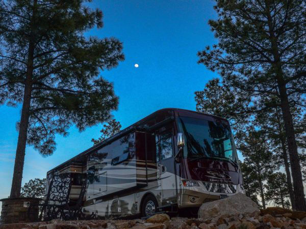 View of RV at dusk with moon in the sky