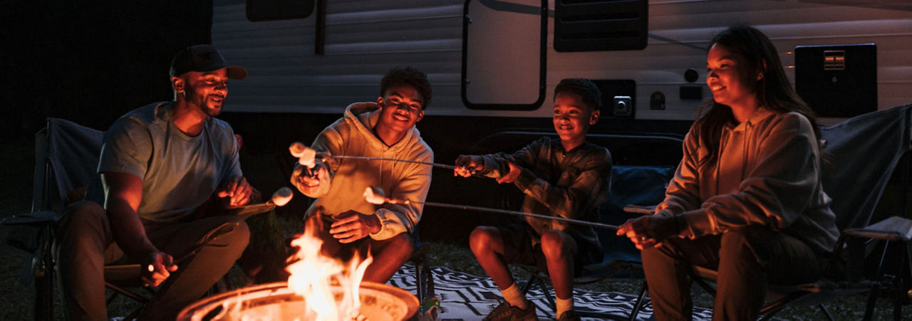 family roasting marshmallows over a fire