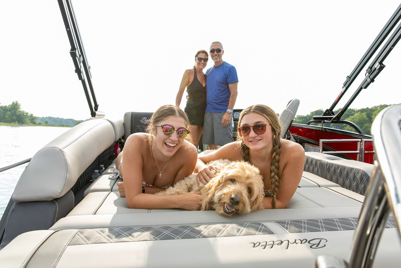 girls posing with dog on a bot