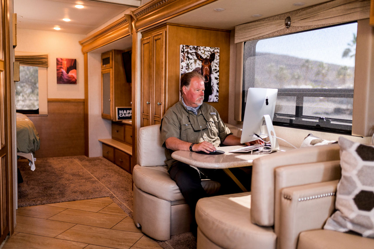Man working on laptop in Newmar coach