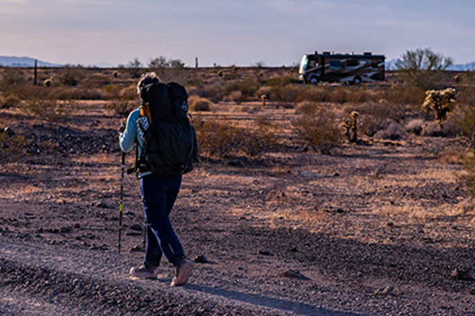 Woman hiking in Arizona going toward a Newmar coach