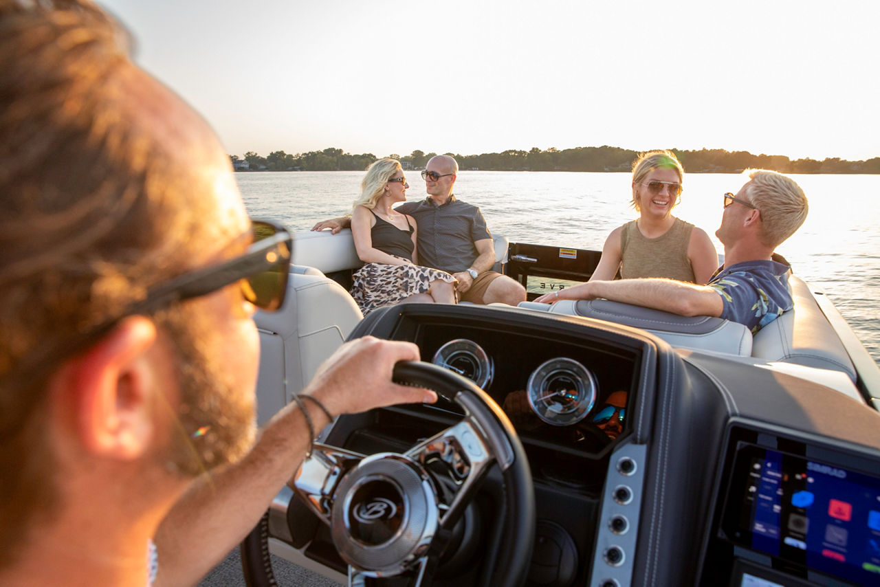 view behind boat driver of two couples in front of boat on the water