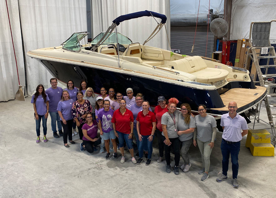 Group of people with a boat behind them