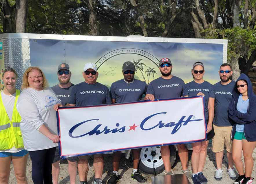 People holding a chris craft sign 