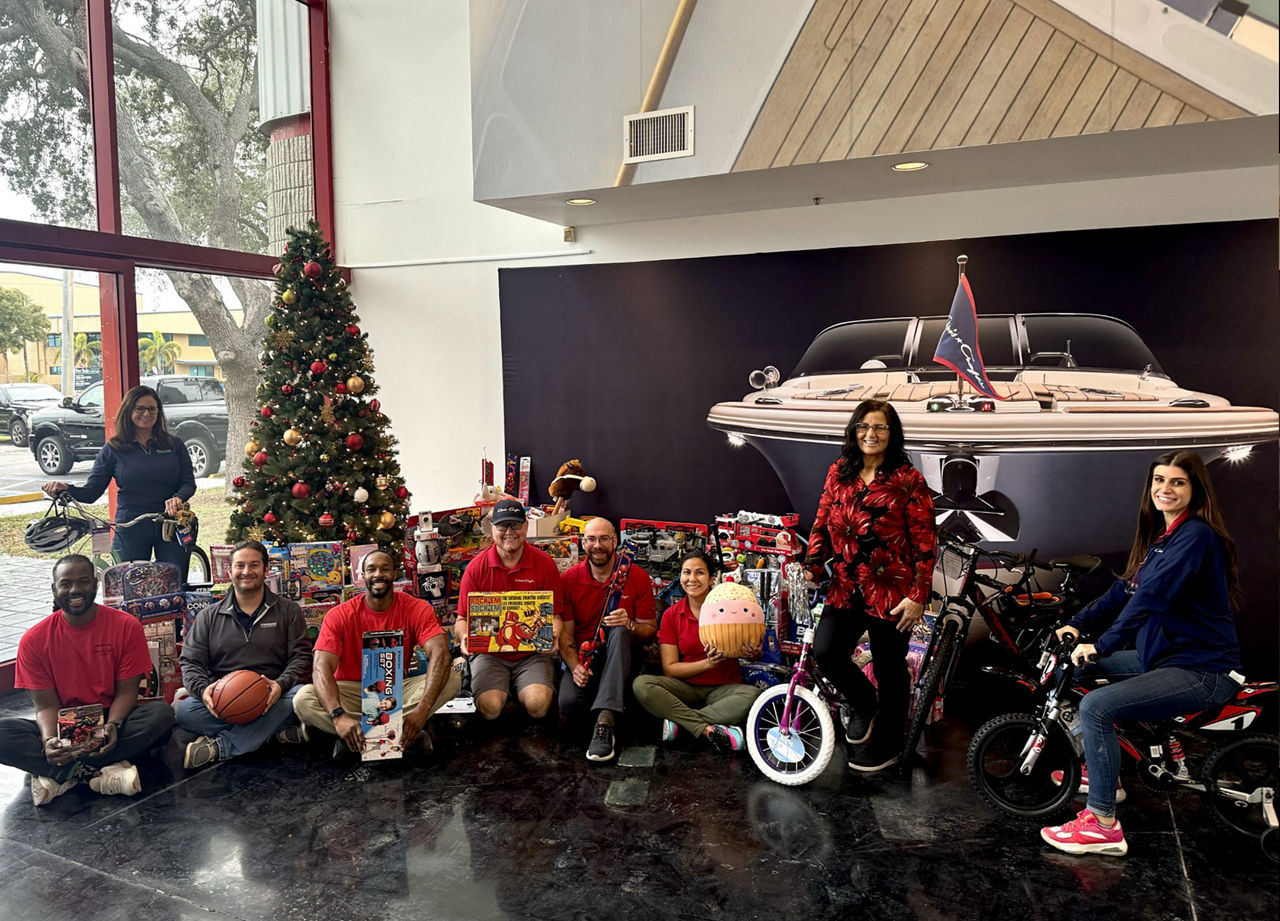 Employees with the gifts donated for Toys For Tots