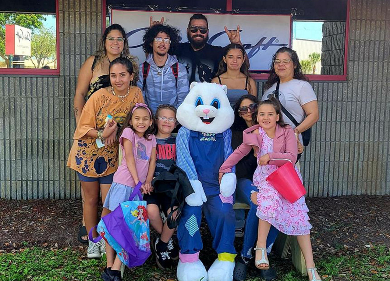 A group of employees and their family meeting the easter bunny