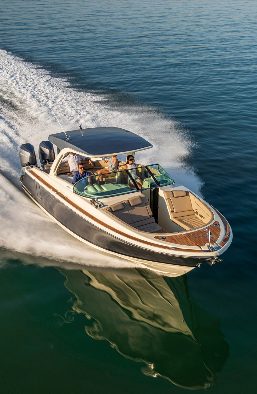 Chris craft boat on the water moving to the right