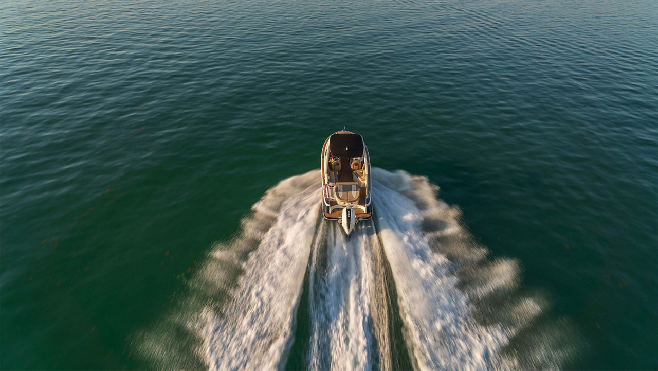 Launch 25 GT boat sailing forward on the ocean with water trailing behind it