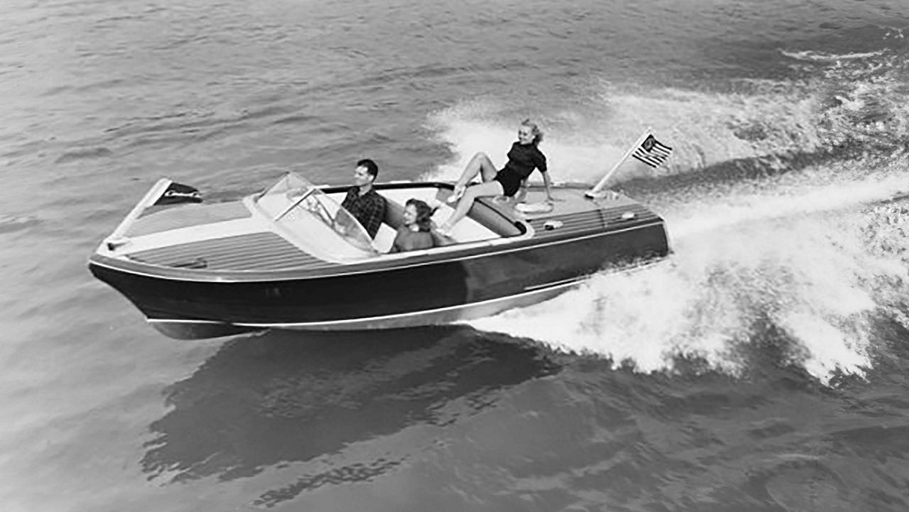 Chris craft boat on the water moving towards the right