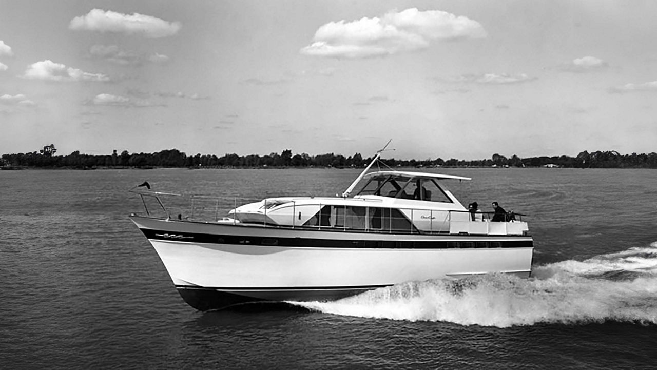 A chris craft boat on the water facing the left