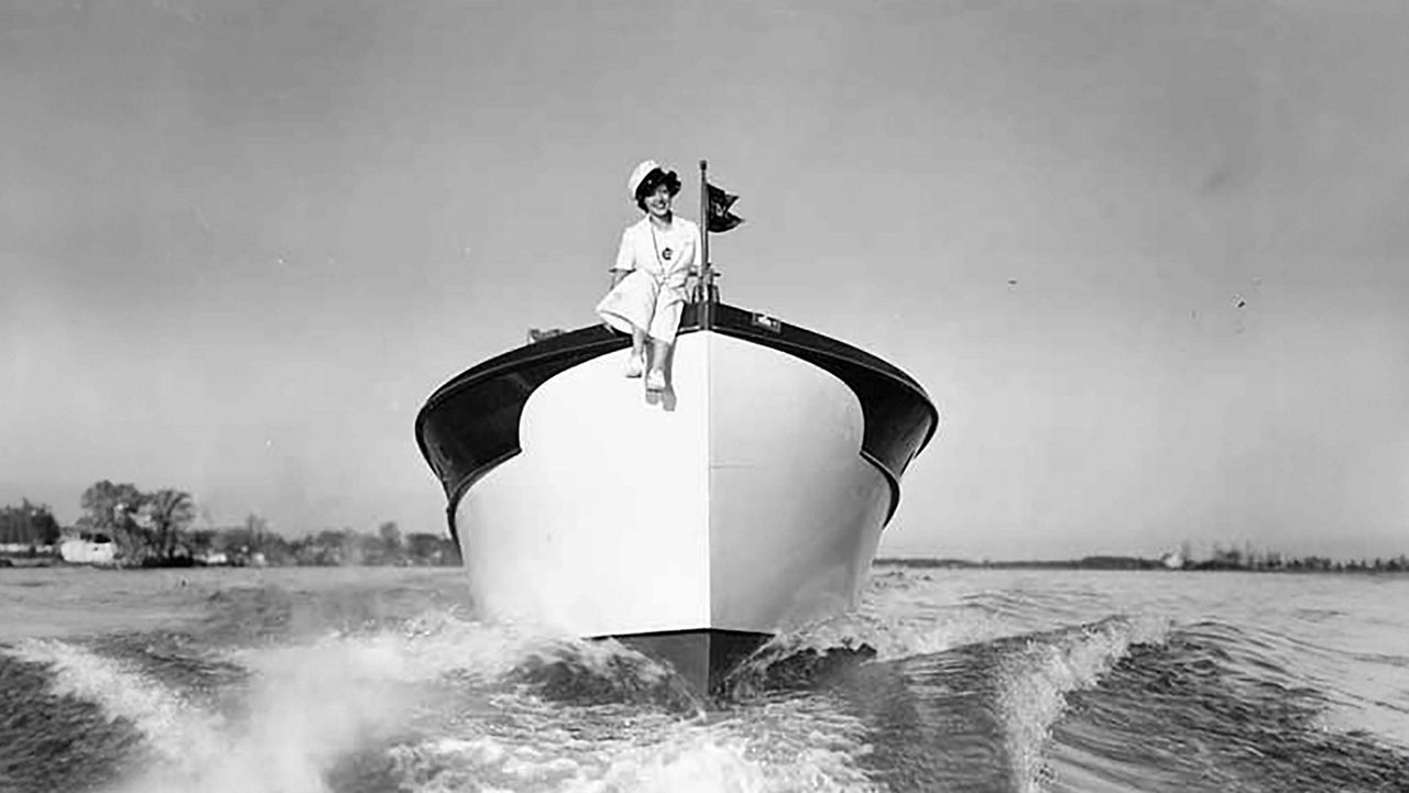 The front of a chris craft boat with a person sitting on the front