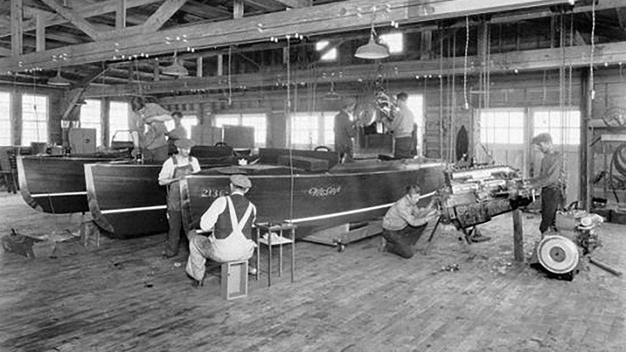 Chris Craft boats in a shot being painted by employees
